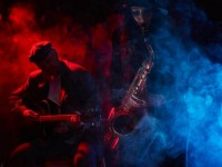 40328898-saxophonist-beautiful-young-woman-smoky-stage-and-guitarist-on-background