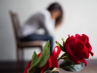 sad-woman-sitting-and-crying-with-red-rose-in-focus_53476-2191